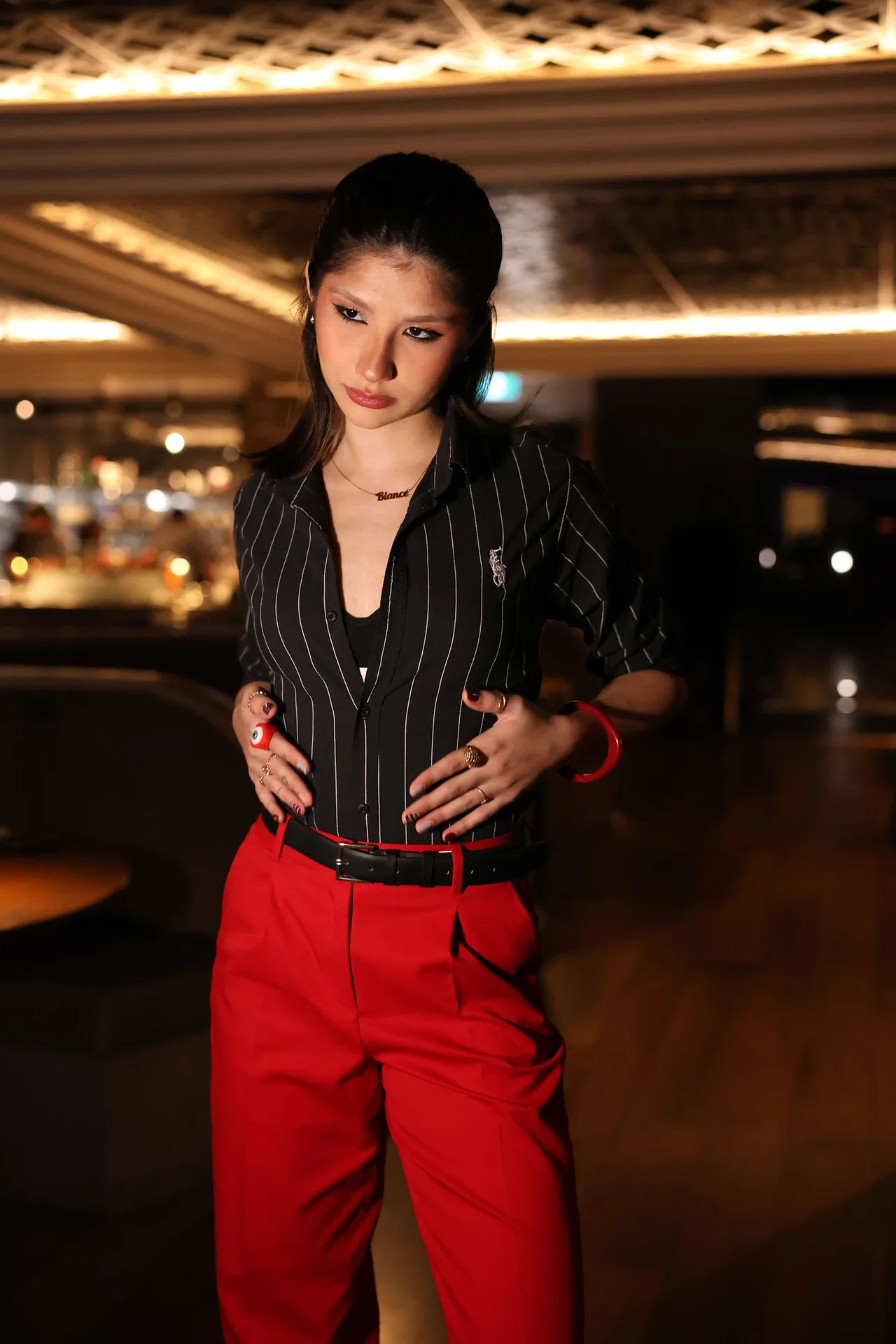 A guest in a pinstripe shirt and red trousers in the dining room.