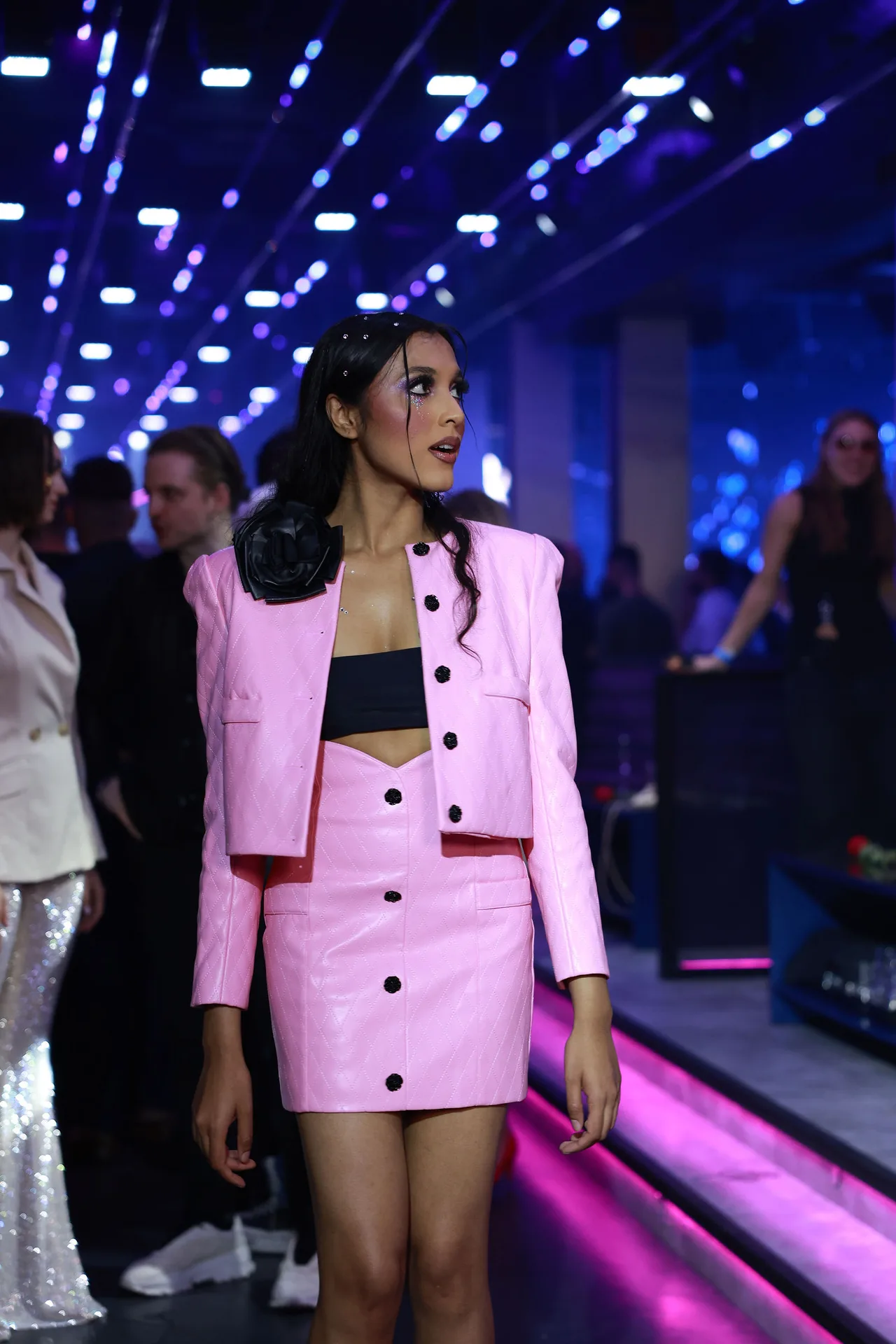 A model in a pink cropped jacket and skirt on the runway.