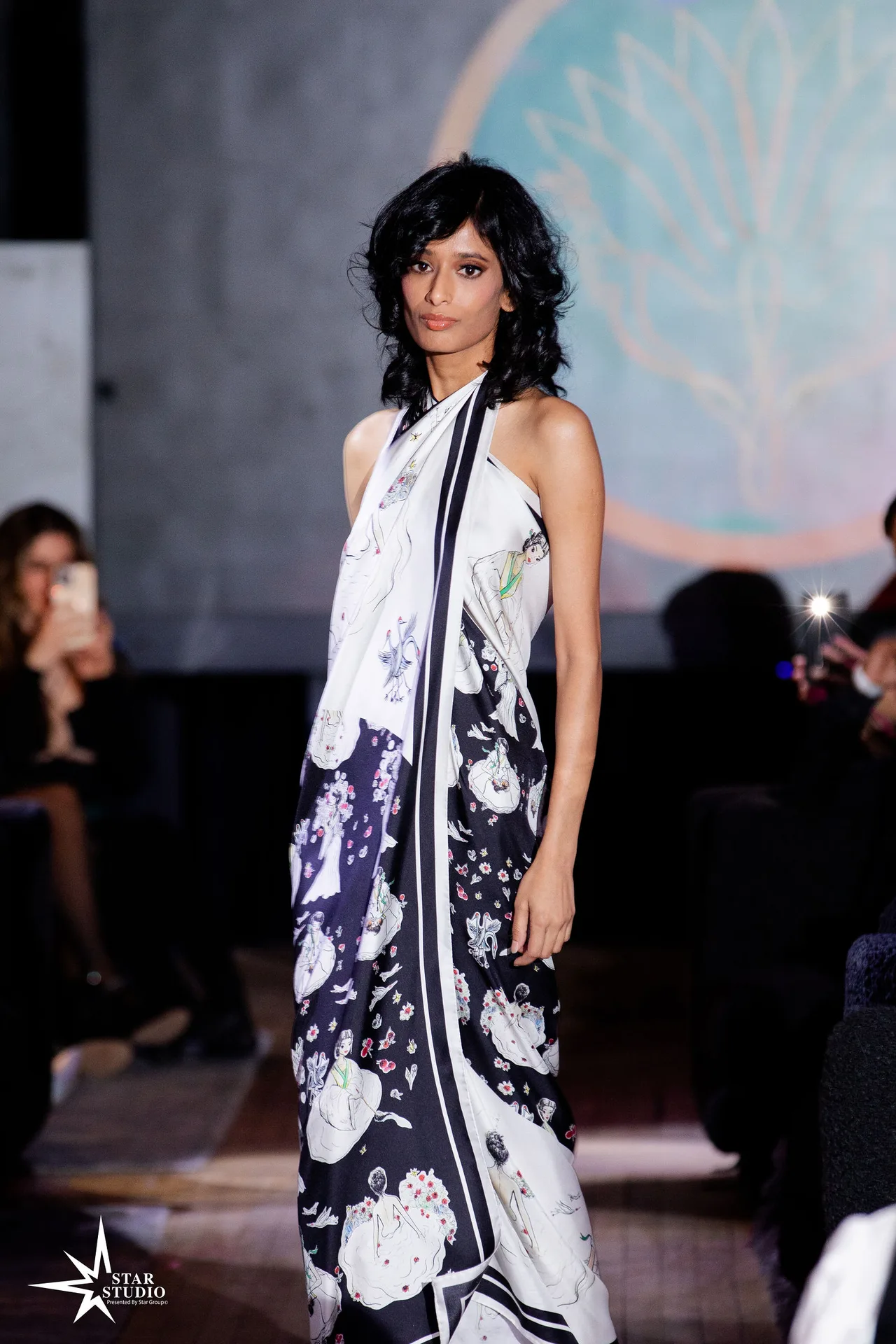 A model in a black-and-white floral silk wrap gown.